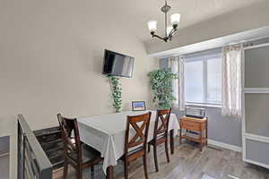 Dining area, a notable chandelier, wood finished floors