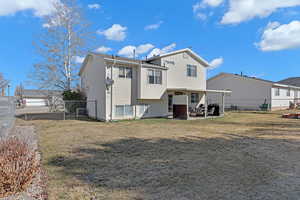 Back of property with a patio, a lawn, and fence