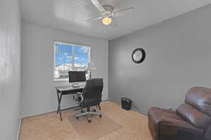 Office area with carpet floors, baseboards, and a ceiling fan