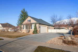 View of front of property featuring a garage, concrete driveway, a gate, fence, and stucco siding