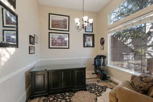 Office area featuring baseboards, an inviting chandelier, and crown molding