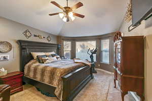 Bedroom with lofted ceiling, carpet flooring, a ceiling fan, and baseboards