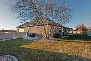 Rear view of property featuring a fenced backyard, a lawn, a patio, and stucco siding