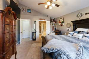 Bedroom with lofted ceiling, baseboards, a ceiling fan, and light colored carpet