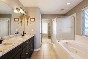Bathroom with a stall shower, a sink, and tile patterned floors
