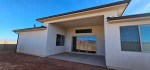 Property entrance featuring a patio, fence, and stucco siding