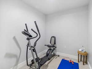 Exercise room with baseboards and carpet flooring
