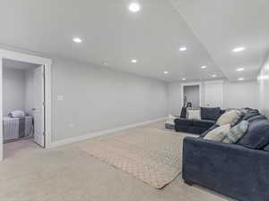 Living room featuring baseboards, recessed lighting, and light colored carpet
