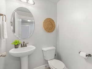Half bath featuring baseboards and toilet