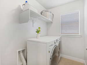 Laundry area featuring laundry area, baseboards, washer and clothes dryer, and light tile patterned flooring