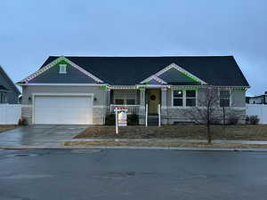 View of front of home featuring fence, an attached garage, stucco siding, concrete driveway, and stone siding