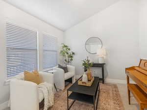 Sitting room featuring vaulted ceiling and baseboards