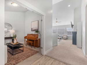 Corridor featuring carpet floors, baseboards, and wood finished floors
