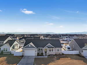 View of front facade with a residential view, fence, a mountain view, and concrete driveway