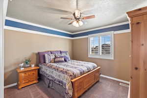 Bedroom with carpet floors, visible vents, baseboards, and a textured ceiling