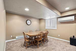 Carpeted dining room featuring a textured ceiling, recessed lighting, baseboards, a wall mounted AC, and baseboard heating