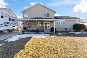 Rear view of property featuring a patio area and a lawn