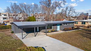 View of front facade with driveway, a residential view, a front lawn, and an attached carport