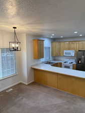 Kitchen featuring white appliances, a sink, visible vents, light countertops, and carpet