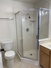 Full bath featuring toilet, a shower stall, and vanity