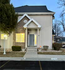 View of front of house with brick siding and stucco siding