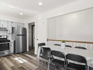 Kitchen featuring recessed lighting, backsplash, light wood-style flooring, appliances with stainless steel finishes, and under cabinet range hood