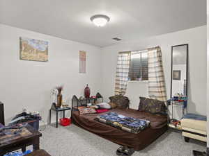 Carpeted bedroom featuring visible vents and baseboards