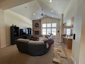 Living area featuring lofted ceiling, a brick fireplace, baseboards, and a textured ceiling