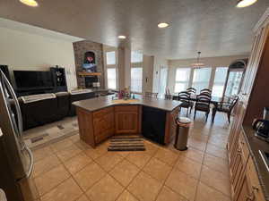 Kitchen featuring black dishwasher, light tile patterned floors, a sink, and freestanding refrigerator