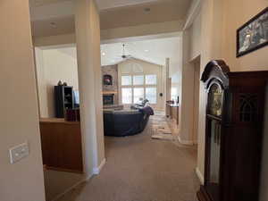 Hall with lofted ceiling, recessed lighting, baseboards, and light colored carpet