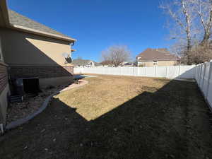 View of yard with a fenced backyard and central air condition unit