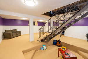 Finished basement featuring new carpet, wainscoting, and sunken play area