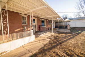 Back of home with covered patio and separate entrance to the basement