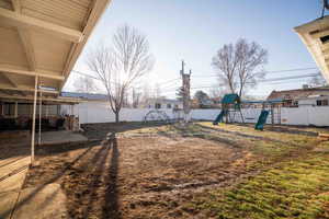 View of yard with a patio area, a playground, and a fenced backyard