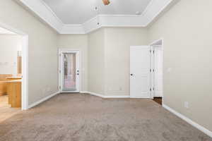 Unfurnished bedroom with a raised ceiling, ensuite bathroom, light carpet, access to outside, and baseboards