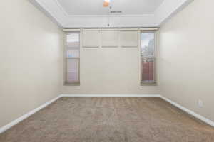 Carpeted empty room with a ceiling fan, visible vents, and baseboards