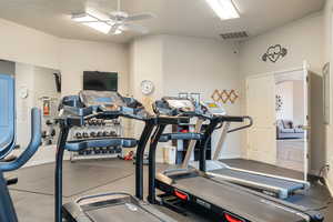 Club House. Workout area featuring a ceiling fan, arched walkways, visible vents, and baseboards