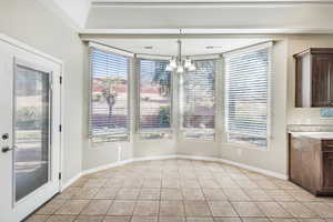 Unfurnished dining area with visible vents, baseboards, a notable chandelier, and light tile patterned flooring