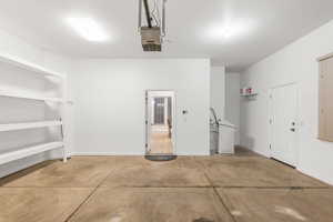 Garage featuring baseboards and a garage door opener