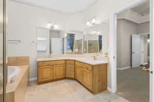 Full bathroom with a sink, double vanity, an enclosed shower, and a garden tub