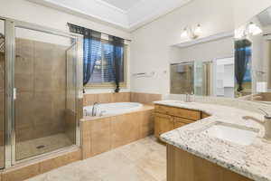 Full bathroom featuring a stall shower, a garden tub, a sink, and tile patterned floors