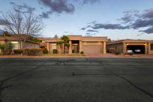 Adobe home with a garage, driveway, and stucco siding