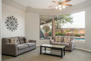 Club House. Living room featuring baseboards, carpet, visible vents, and a ceiling fan