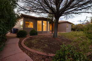 Back of property with a tiled roof and stucco siding