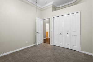 Unfurnished bedroom with a closet, carpet flooring, and baseboards