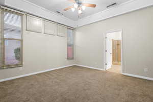 Carpeted spare room featuring baseboards, visible vents, and a ceiling fan