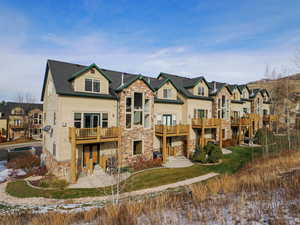 Exterior space with stone siding, a residential view, and a patio