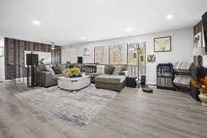 Living room featuring baseboards, wood finished floors, and recessed lighting