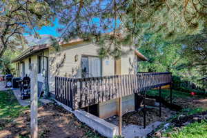 View of side of property featuring brick siding and a wooden deck