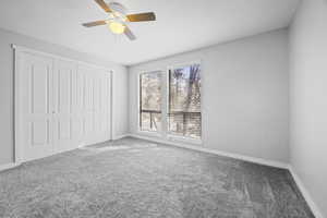 Unfurnished bedroom featuring carpet floors, a ceiling fan, baseboards, and a closet